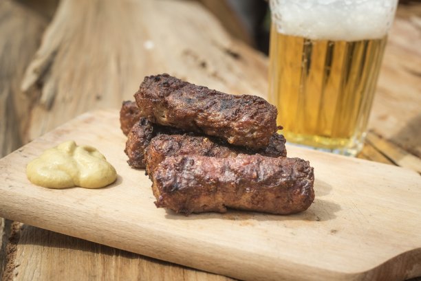 Mici cu是庆祝5月1日劳动节的传统罗马尼亚菜。遇见球、肉卷、菜和啤酒图片下载