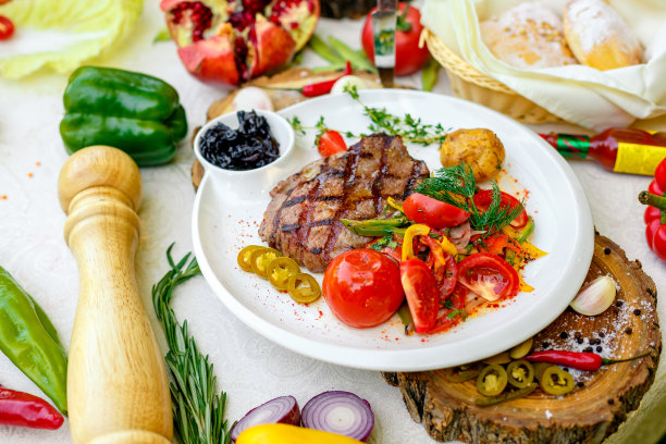 烧烤，多汁的牛排配烤蔬菜和酱汁在一个白色的盘子里图片下载