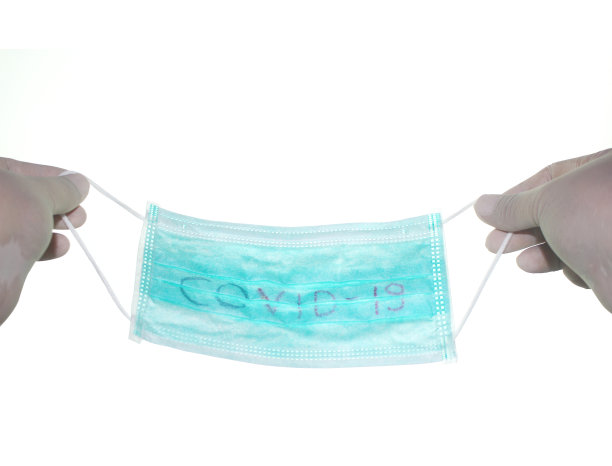 手拿医用口罩，保护COVID-19病毒图片下载