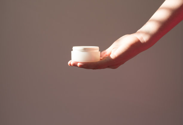 女性手部护肤包装。面部肌肤美容产品，植物阴影白底。Scincare化妆品的概念图片下载