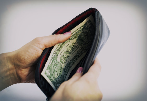 一个女人数着钱包里的美元。最后的法案。钱。手里拿着美元的特写照片图片下载