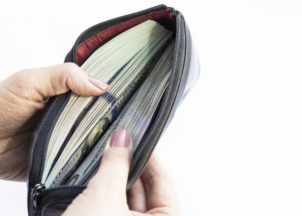 一个女人数着钱包里的美元。女人会数钱。钱。手里拿着美元的特写照片图片下载