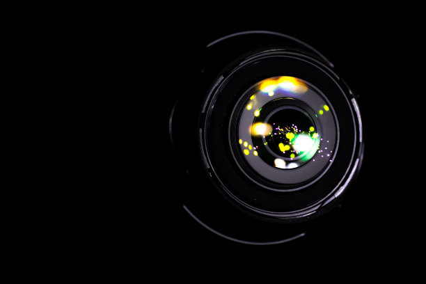 透镜的光。照片上的闪光反射，黑色背景上的摄像机。闪烁着圆形和六角形，彩虹光环。图片下载