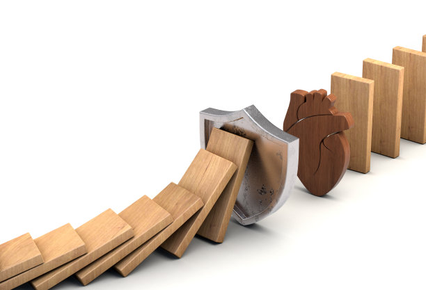 盾牌停止倒下的木制多米诺骨牌。心脏保护的概念。心脏病风险。图片下载