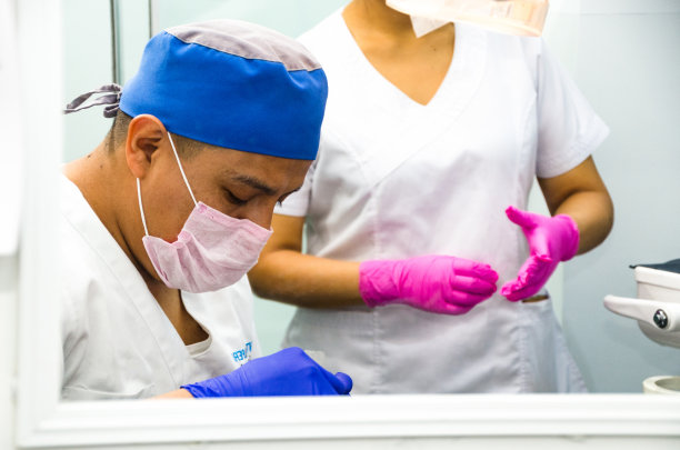 两名外科医生的照片，穿着制服，看着摄像机。图片下载