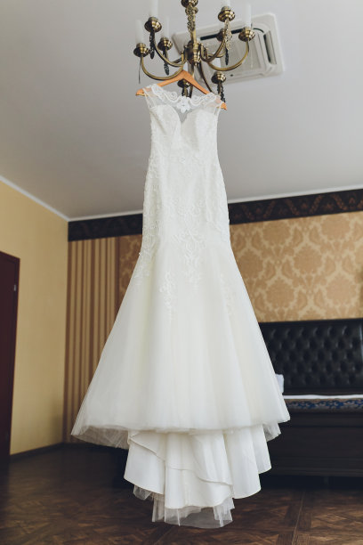 米色婚纱挂在吊灯上。图片下载