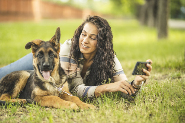 一个女人和她的狗在她的手机自拍图片下载