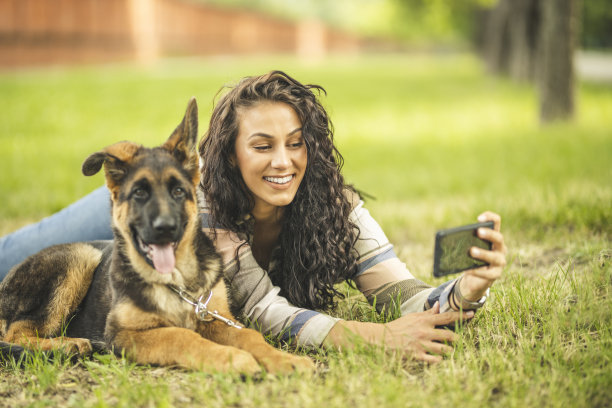 一个女人和她的狗在她的手机自拍图片下载