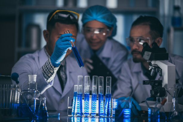 亚洲科学家在实验室里拿着一个装满液体的试管图片下载