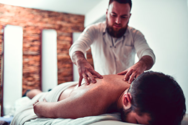 专业理疗师对年轻男性的按摩治疗图片下载