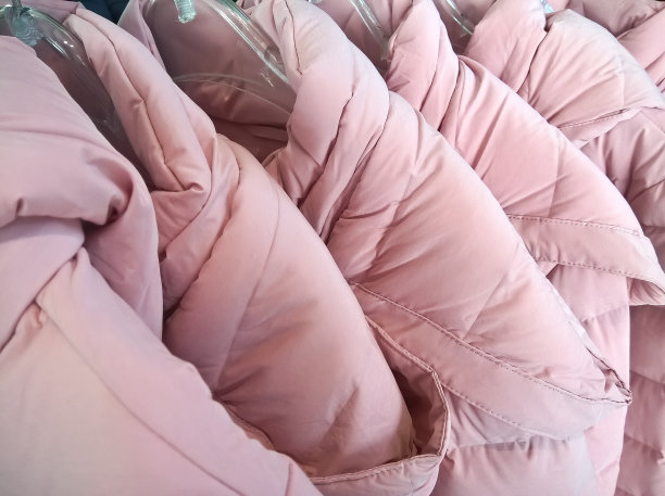 多色羽绒服的衣架在商店出售。图片下载