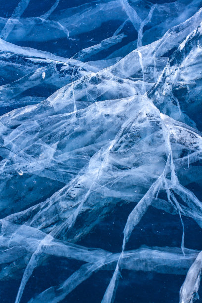 别致的图案从冰的裂缝。天然质地，纯碎冰。蓝色的厚冰。垂直的。图片下载