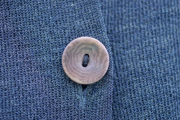 棕色纽扣在灰黑色面料衣服上图片下载