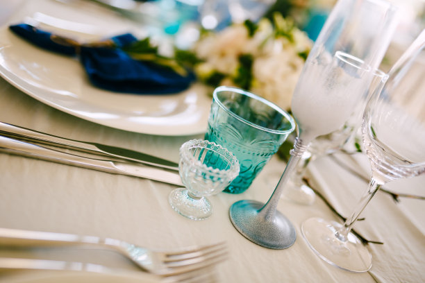 餐桌上的婚礼晚宴特写。盛放葡萄酒和香槟的酒杯和酒杯摆放在节日的餐桌上。为婚宴上的宴席服务。图片下载