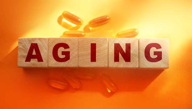 老化的词在木方与油丸周围在橙色的背景。医疗保健的概念图片下载