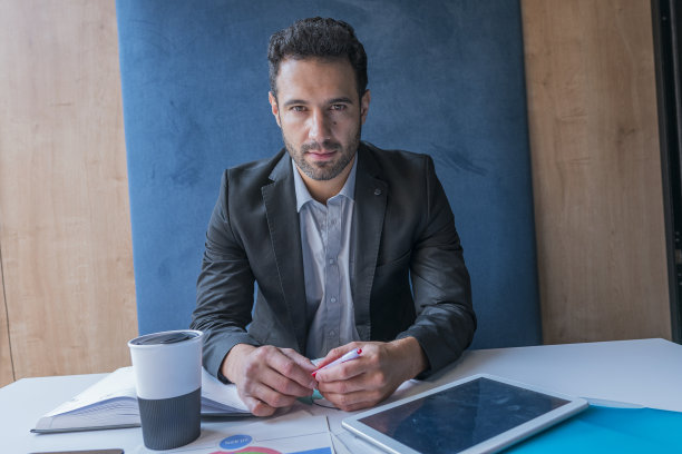 一位主管在他的办公室里看着一幅肖像中的照相机图片下载