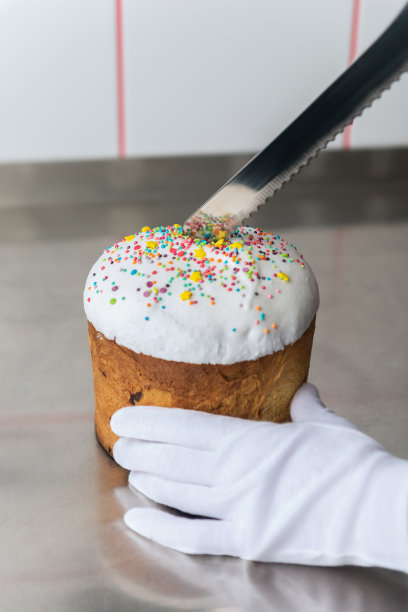 手在白手套切复活节蛋糕与白色的顶部图片下载