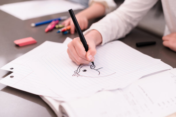 小学女孩在纸上画画;在学业上分心图片下载