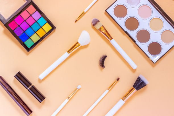 一套专业的装饰性化妆品配饰品。化妆刷，眼影，黑色睫毛膏，轮廓调，轮廓口红，假睫毛，背景颜色。化妆和美容的概念。图片下载