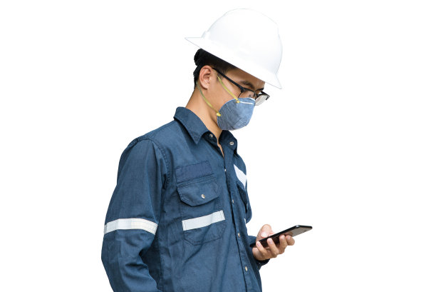 亚洲工程师戴着N95口罩过滤pm2.5，防污染，防雾霾和病毒。空气污染，与智能手机概念隔离在白色背景。图片下载