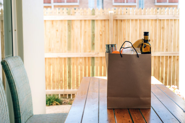 房子后院里的木桌上放着装着食物的纸袋。图片下载