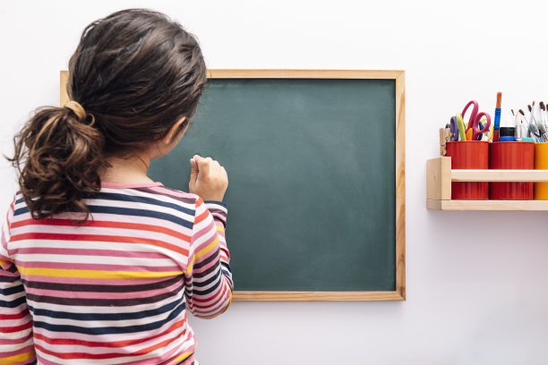 小女孩在空白的黑板上画画图片下载