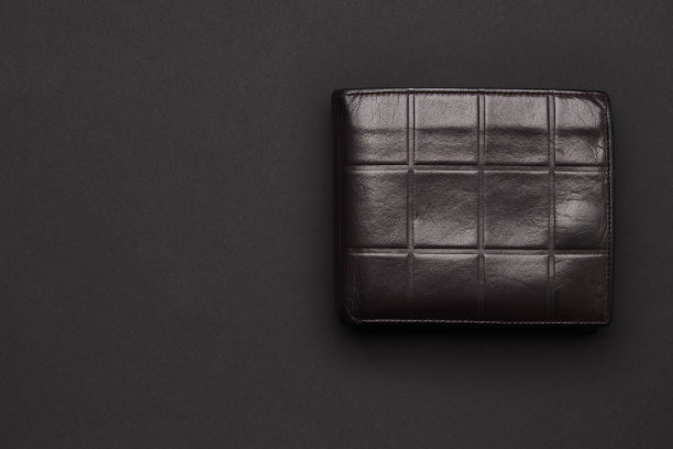 黑色背景上的棕色皮夹。从以上观点。影棚拍摄。复制空间设计。投资储蓄理念。图片下载