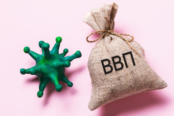 碑文用俄文写着:GDP。玩具冠状病毒和刻有铭文的包。2019冠状病毒病大流行对俄罗斯联邦GDP影响的概念图片下载