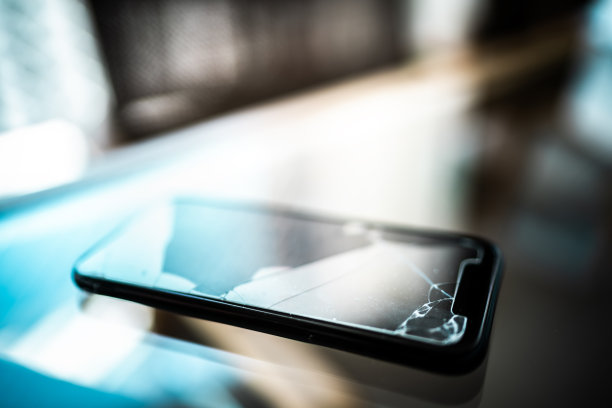 桌子上破碎的手机屏幕图片下载