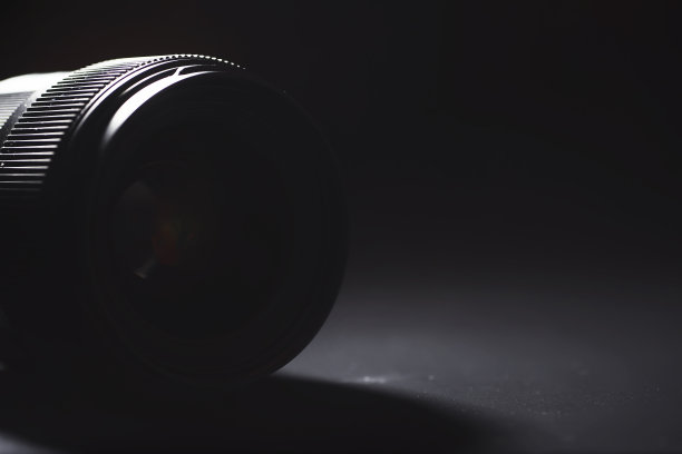 镜头对准操作员桌上的摄像机。照片镜头玻璃上的光斑。背景与摄影师的技术。图片下载