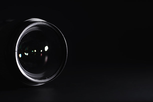 镜头对准操作员桌上的摄像机。照片镜头玻璃上的光斑。背景与摄影师的技术。图片下载