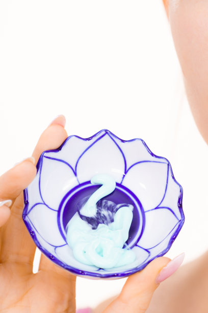 女孩拿着一个有绿色泥面膜的碗图片下载