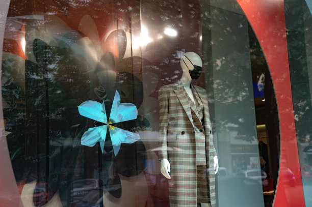 新冠肺炎/冠状病毒大流行期间，商店橱窗里戴着防护口罩的全身人体模型图片下载