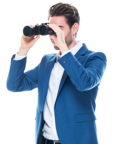 白人男性商人站在白色背景穿着纽扣衬衫和拿着双筒望远镜图片下载