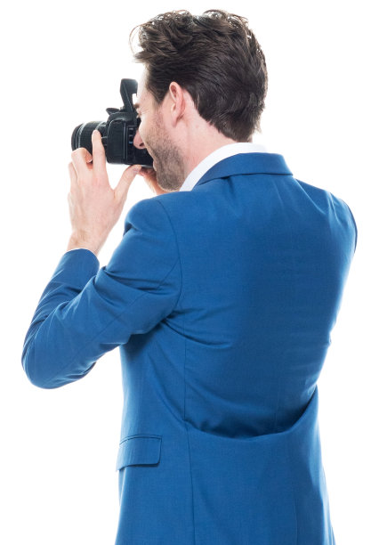 白人年轻男性摄影师站在白色背景穿着夹克和拿着相机图片下载