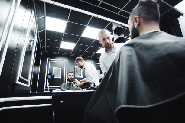师傅在理发店里为男人理发和刮胡子，美发师为年轻人做发型图片下载