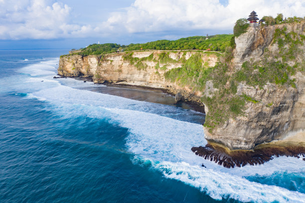 蓝色的海洋和被热带植物覆盖的悬崖。从上面看巴厘岛海岸。空中无人机拍摄。图片下载