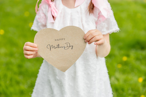 女孩手持心形贺卡，祝母亲节快乐图片下载