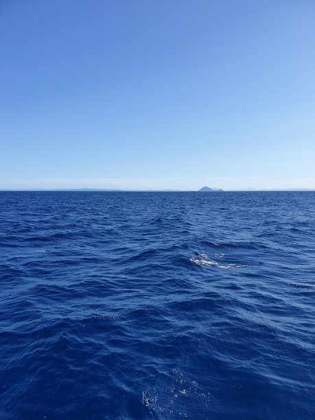 深蓝色的海水，远处有一个小岛图片下载