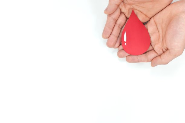 献血和世界献血者日的概念。手上有一滴血。白色背景。图片下载