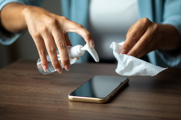 女人用湿纸巾和酒精凝胶的照片清洁手机图片下载