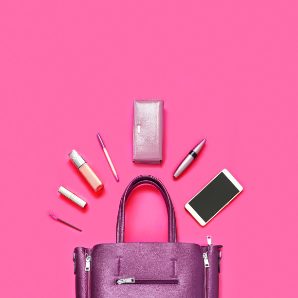 皮包，钱包，手机，化妆品，其他女性配件在粉红色的纸背景。图片下载