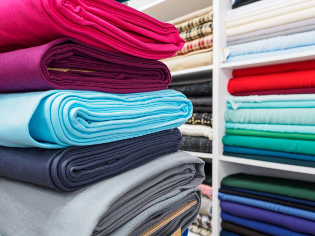 时尚明亮的面料在特写收集。缝纫时装系列服装的不同天然面料样品。商店里有大量的布料可供选择图片下载