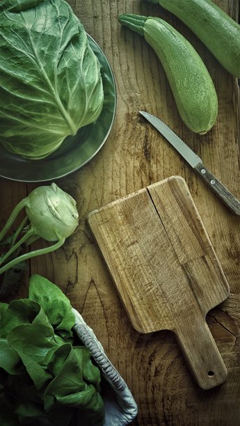 平铺新鲜的绿色蔬菜，大头菜，萝卜，卷心菜和西葫芦在木桌和木制砧板模型在低光摄影图片下载