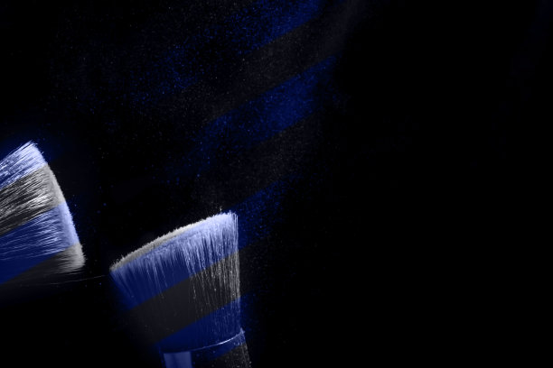 两个化妆刷与飞色粉，产品在黑色背景。简约的黑色是魅力的概念图片下载