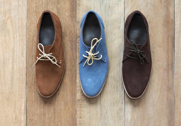 男人鞋与不同的颜色在一个木制的背景。时尚广告鞋照片。俯视图图片下载