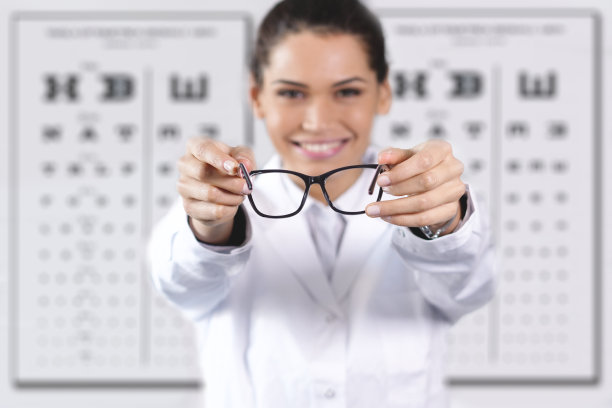 眼科医生在光学中心为顾客做视力检查。图片下载