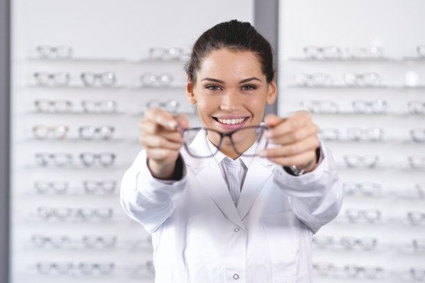 眼科医生在光学中心为顾客做视力检查。图片下载