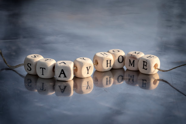 待在家里的文字与字母立方体串在一根线在镜子的背景反射。图片下载