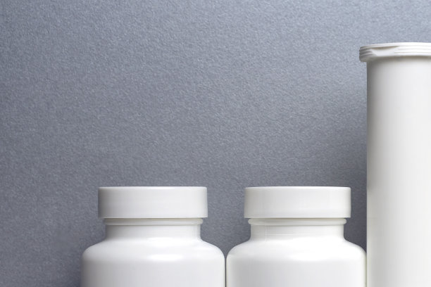 灰色背景是三个包装预防covid -19的药丸和维生素的塑料罐。没有瓶子标签的照片图片下载